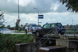 Auto botst tegen hekwerk van brug en komt boven water tot stilstand aan de Langereis